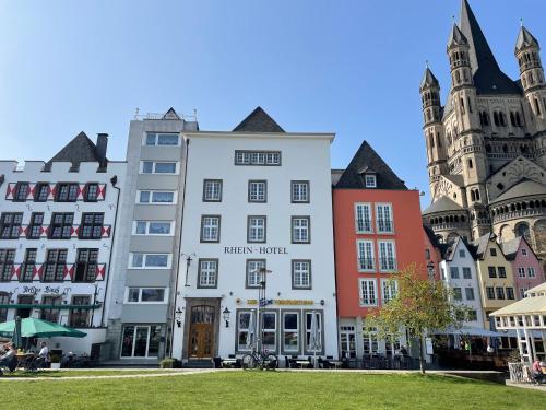 Rhein Hotel St. Martin في كولونيا: مجموعة مباني في مدينة بها كنيسة