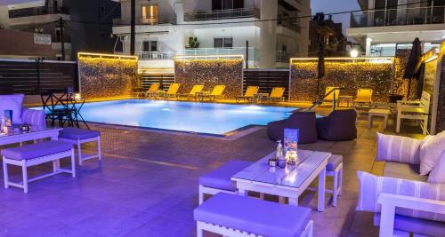 a pool with tables and chairs in front of a building at Majestic Hotel - Adults Only in Rhodes Town