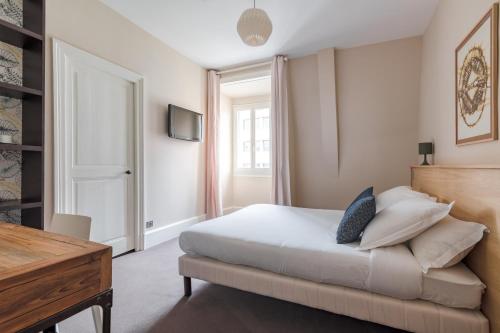 a bedroom with a bed and a desk and a television at Les Argentiers - Accès digitalisé in Limoges