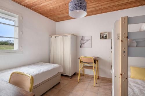 - une chambre avec des lits superposés, une table et des chaises dans l'établissement Maison de vacances à 2 pas de la plage du Portmain, à Pornic
