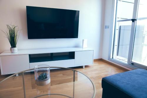 sala de estar con TV y mesa de cristal en Apartamento Centro Castellón con Parking 1 en Castellón de la Plana