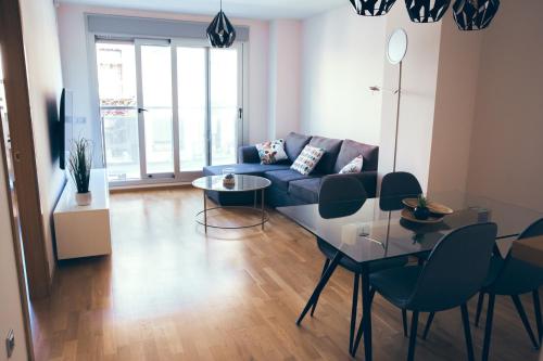 sala de estar con sofá, mesa y sillas en Apartamento Centro Castellón con Parking 1 en Castellón de la Plana