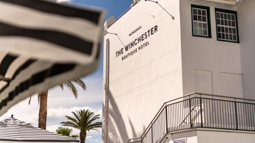 an american flag flying in front of a building at The Winchester Hotel by NEWMARK in Cape Town