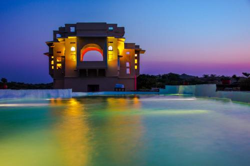 een gebouw met 's nachts lichten in het water bij Brij Lakshman Sagar, Pali in Raipur