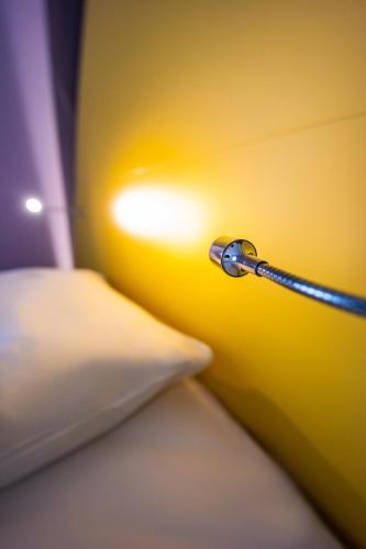 a bed with a lamp next to a pillow at Prize by Radisson, Bonn City in Bonn