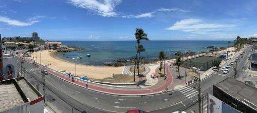 uma vista para uma estrada com uma praia e o oceano em Rede Andrade Mar Hotel - Rio Vermelho em Salvador