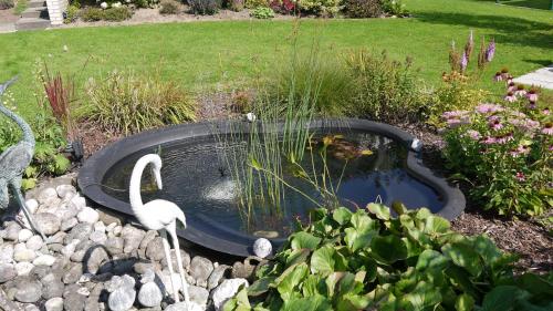 a bird bath with two flamingos in a garden at Ferienwohnung und Gästezimmer Iburgblick in Bad Driburg