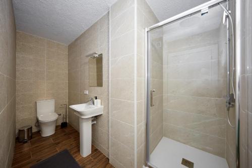a bathroom with a shower and a sink and a toilet at El Patio Hostal in Alicante