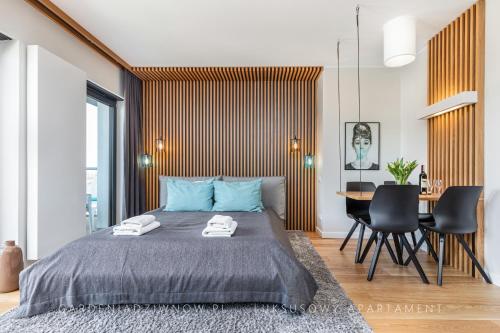 a bedroom with a bed and a table and chairs at Audrey DeLux Seaview Gardenia Studio in Dziwnów