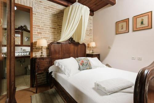 a bedroom with a bed and a brick wall at Casa Di Veneto in Hersonissos