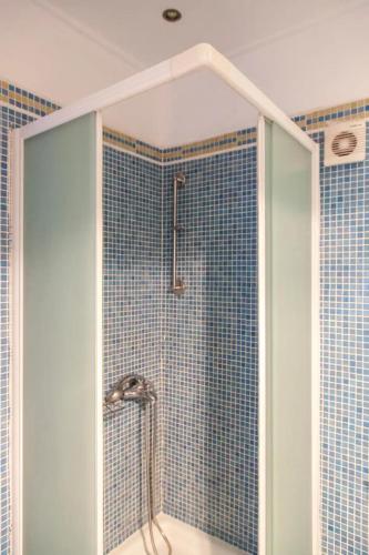 a bathroom with a shower with blue tiles at Villa Anna in Athani