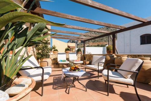 a patio with white chairs and a table at Casa Di Veneto in Hersonissos