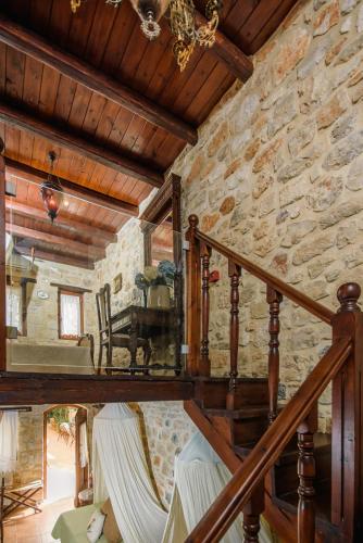 a wooden staircase in a room with a stone wall at Casa Di Veneto in Hersonissos
