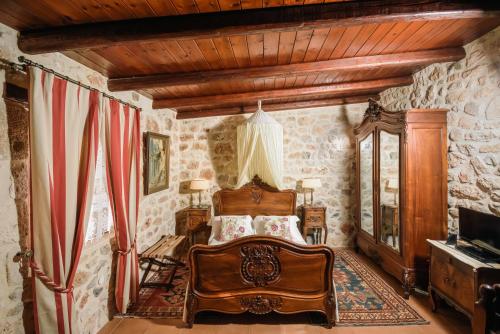 a bedroom with a bed in a room with stone walls at Casa Di Veneto in Hersonissos
