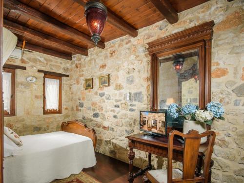 a bedroom with a bed and a table with a mirror at Casa Di Veneto in Hersonissos