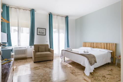 a bedroom with a bed and a chair at Scicli Albergo Diffuso in Scicli