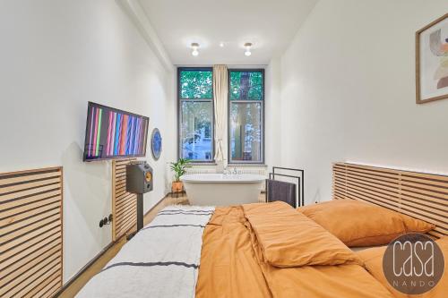 ein Schlafzimmer mit einem Bett und einer Badewanne in der Unterkunft City Apartments Leipzig - Ruhig, zentral & nahe Zoo in Leipzig