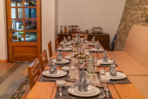 a long table with plates and silverware on it at Seclude Ramgarh Willows in Rāmgarh