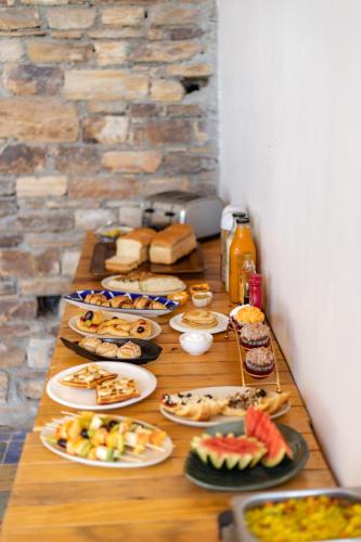 a long wooden table with plates of food on it at Seclude Ramgarh Willows in Rāmgarh