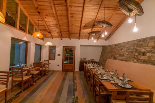 a dining room with tables and chairs and a stone wall at Seclude Ramgarh Willows in Rāmgarh