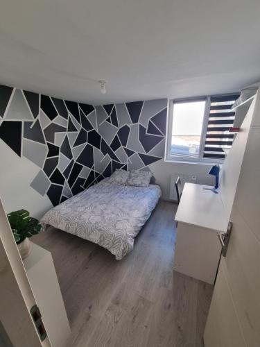 1 dormitorio con cama y pared geométrica en THELNA elya, en Bray-Dunes