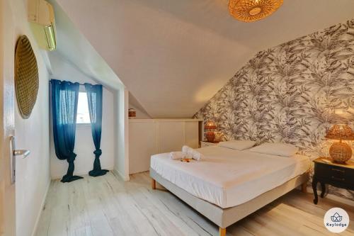 ein Schlafzimmer mit einem Bett und einer Wand in der Unterkunft T4 - Le Romanéla 3 étoiles - 90 m2 - Saint Leu in Saint-Leu