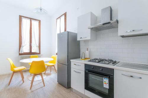 a kitchen with a stove and a table with chairs at Canaletto Apartments in Venice