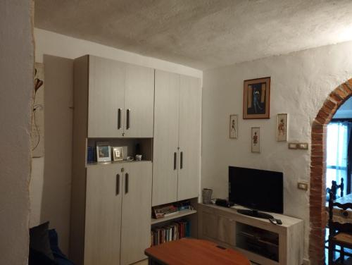 a living room with white cabinets and a television at Il Podere di Massi in Barberino di Mugello