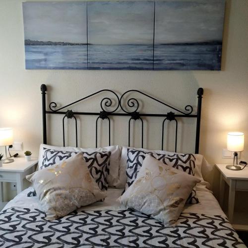 a bed with two pillows and a painting above it at Al-Andalus Thalassa Home Star in Vera