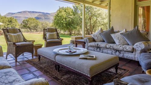 a living room with couches and a table and chairs at Mount Camdeboo Private Game Reserve by NEWMARK in Graaff-Reinet