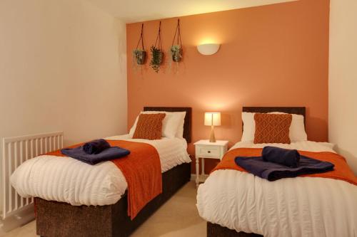 two beds sitting next to each other in a bedroom at Cosy Two Bedroom Coach House - Free Parking for 2 vehicles, WIFI & Netflix in Colchester