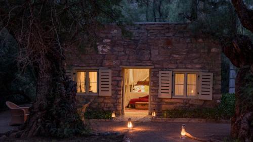 a stone house at night with lights in front of it at Mount Camdeboo Private Game Reserve by NEWMARK in Graaff-Reinet