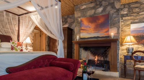 a bedroom with a bed and a fireplace in a room at Mount Camdeboo Private Game Reserve by NEWMARK in Graaff-Reinet