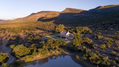 an aerial view of a house with a lake at Mount Camdeboo Private Game Reserve by NEWMARK in Graaff-Reinet