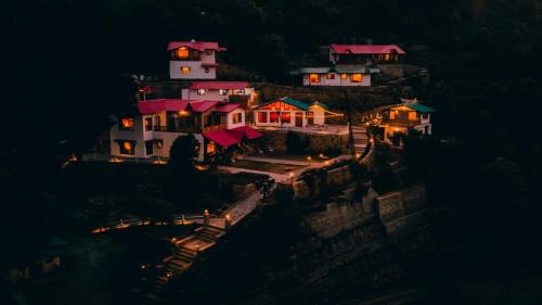 a group of houses on a hill at night at Seclude Ramgarh Willows in Rāmgarh