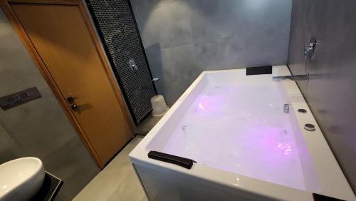 a bathroom with a large tub with a toilet at Hotel Nova Boutique in Rajkot