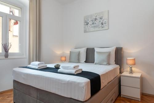a bedroom with a large bed with towels on it at Apartment Silvia in Trogir