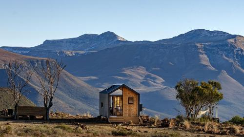 a tiny house in the mountains with a bench at Mount Camdeboo Private Game Reserve by NEWMARK in Graaff-Reinet