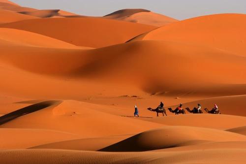 a group of people riding horses in the desert at Merzouga Desert Luxury Camp in Merzouga