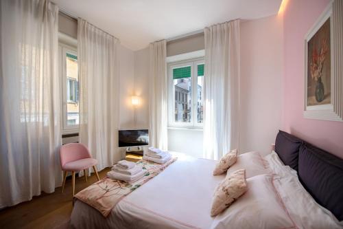 ミラノにあるMadeleine apartments - Breraのベッドルーム(白いベッド1台、ピンクの椅子付)