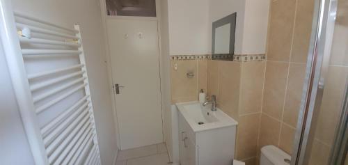 a bathroom with a sink and a toilet and a mirror at Kingsley House in Hastings