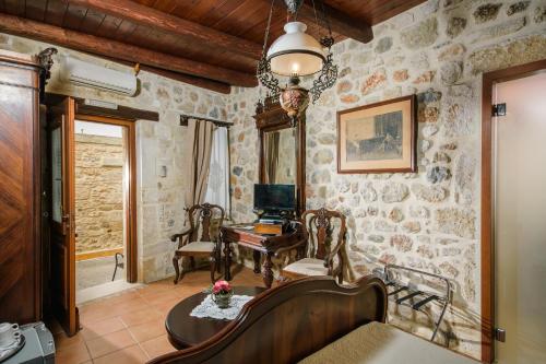 a living room with stone walls and a table and chairs at Casa Di Veneto in Hersonissos