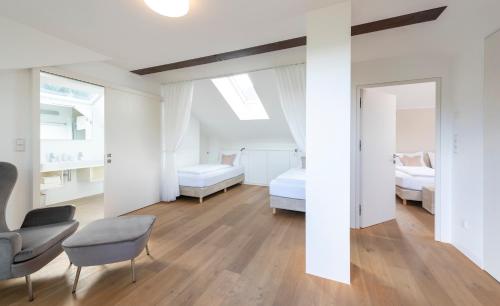a bedroom with two beds and a couch and a chair at Untermargarethenhof in Lana