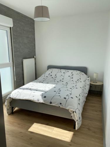 1 dormitorio con 1 cama en una habitación con ventana en Appartement en Beaumont