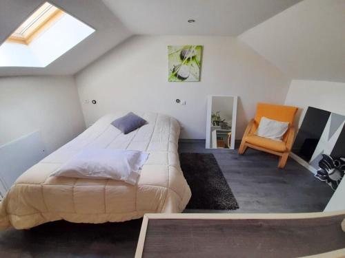 une chambre avec un grand lit et une chaise dans l'établissement Charmante maison à Brévonnes avec jardin clôturé, à Brévonnes