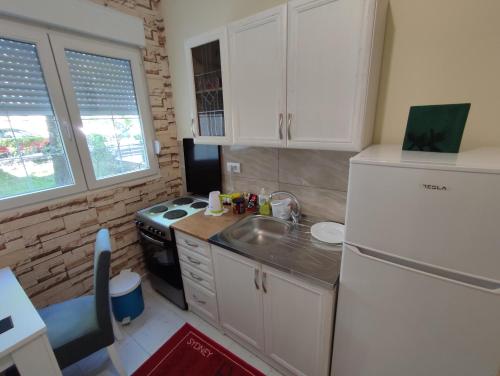 een keuken met een witte koelkast en een wastafel bij Orion Apatman in Belgrado