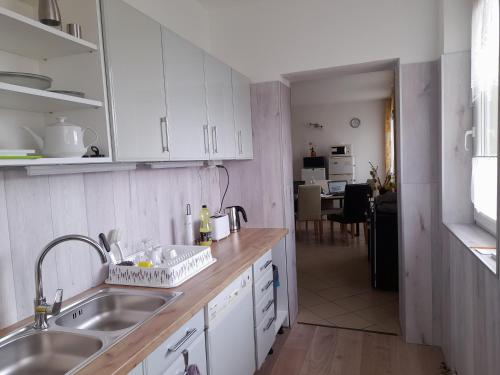 a kitchen with white cabinets and a sink at Anna Vendégház Szeleste in Szeleste