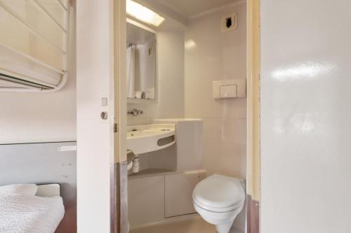 La petite salle de bains est pourvue de toilettes et d'un lavabo. dans l'établissement Première Classe Lille Sud Henin Beaumont, à Noyelles-Godault