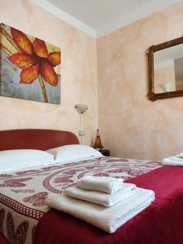 a bedroom with a bed with towels on it at Hotel Glicine in Noli