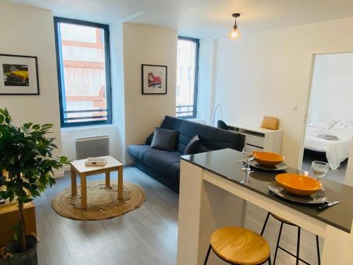 un salon avec un canapé bleu et une table dans l'établissement Le Combarel, à Rodez